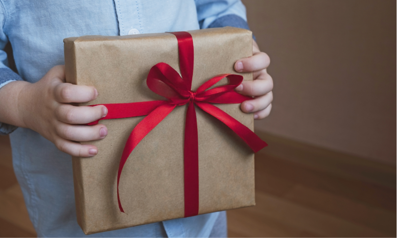 A child holding a wrapped gift with a bow
