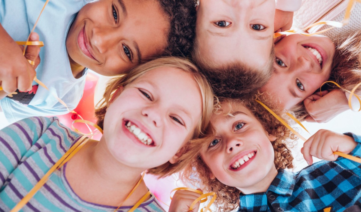 A group of happy children looking down at the camera and smiling