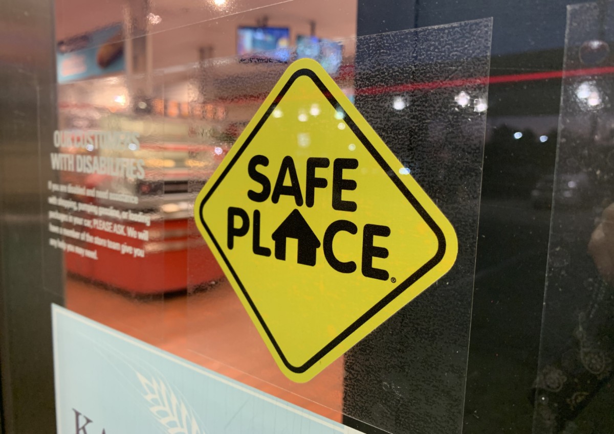 A Safe Place program sign on a building exterior window