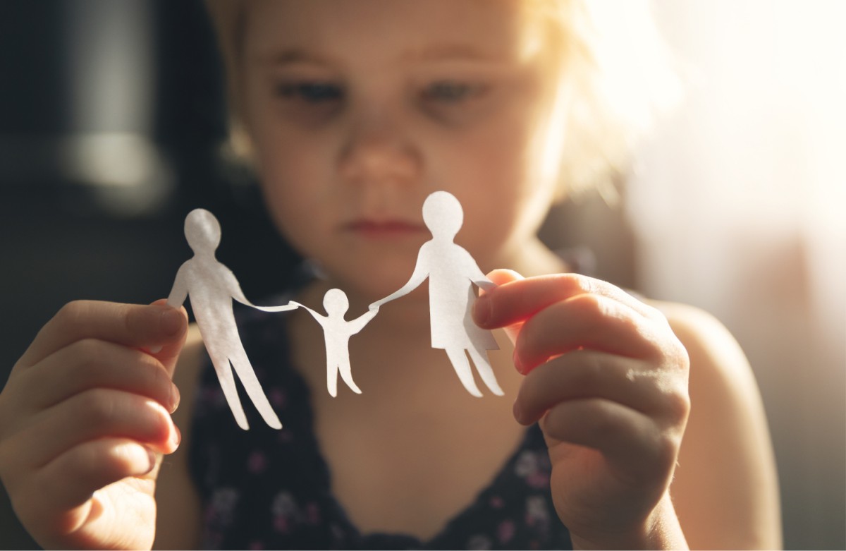 Child holding and looking at a paper family