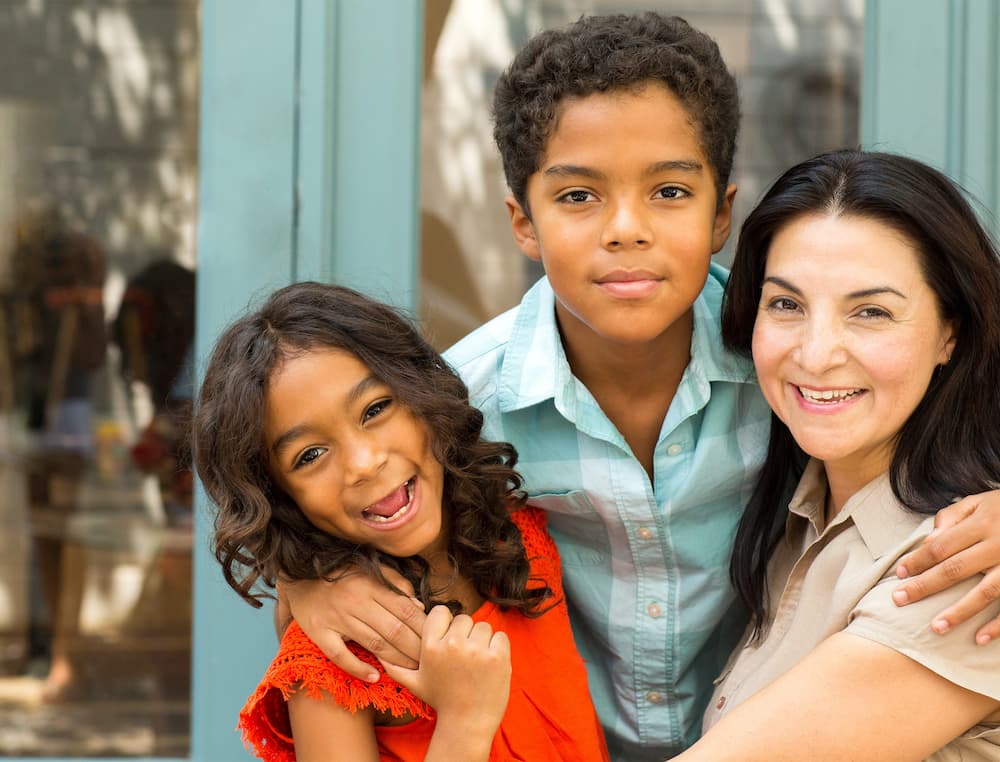 Two children with their mother smiling at the camera
