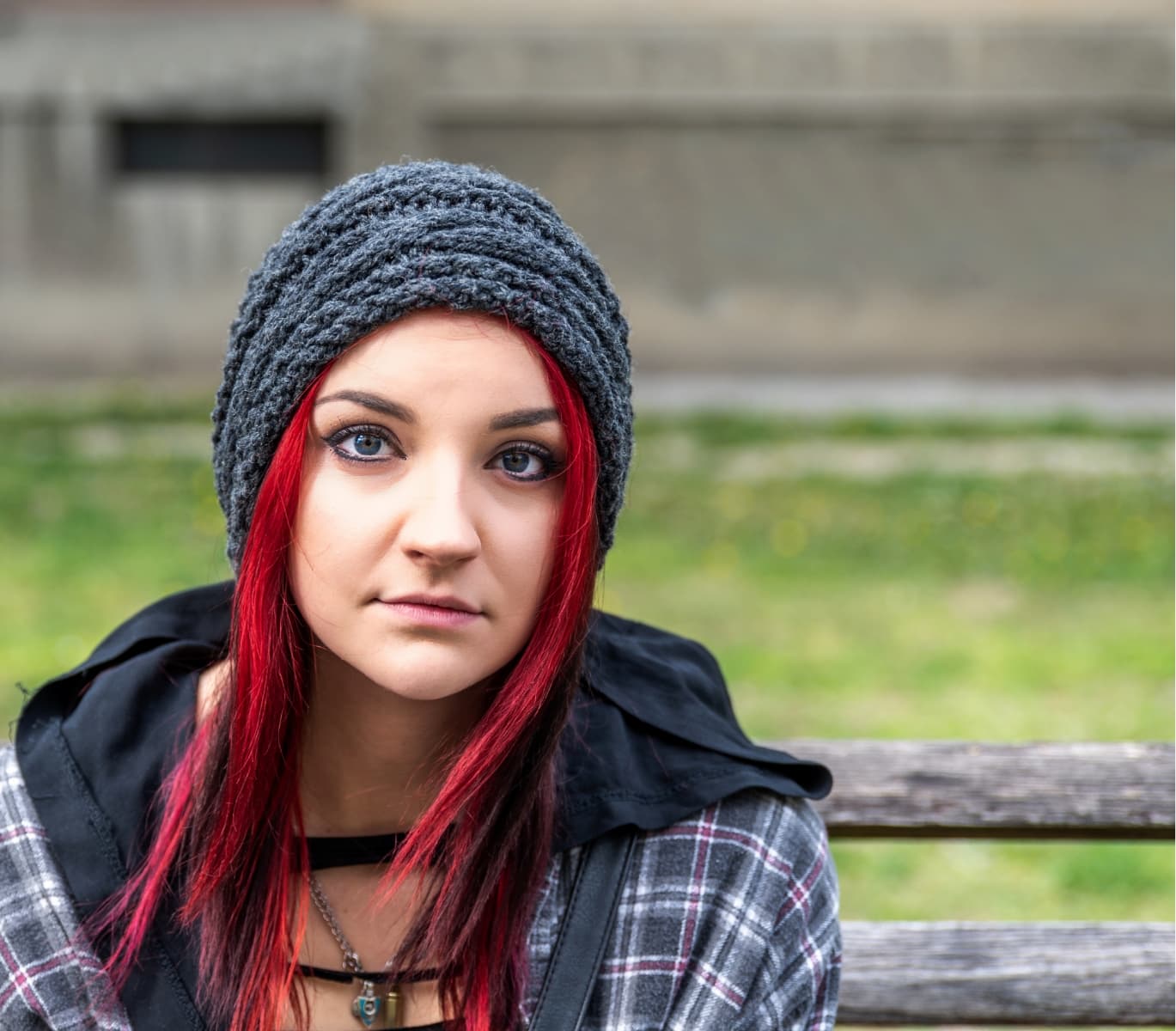 A teenage girl with red hair looking at the camera with a neutral expression