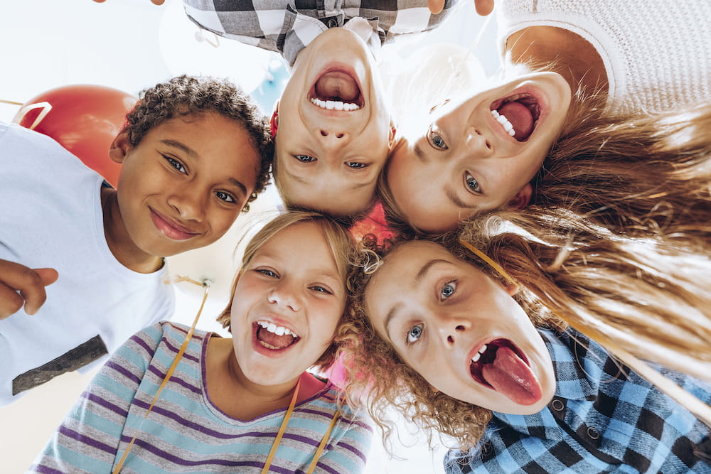 A group of happy children looking down at the camera and smiling