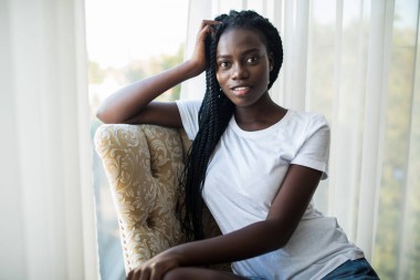 Young woman sitting on a chair smiling at the camera
