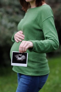 A pregnant woman showing a photo of an ultrasound
