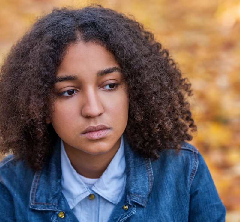 Photo of Ava sitting with a sad expression